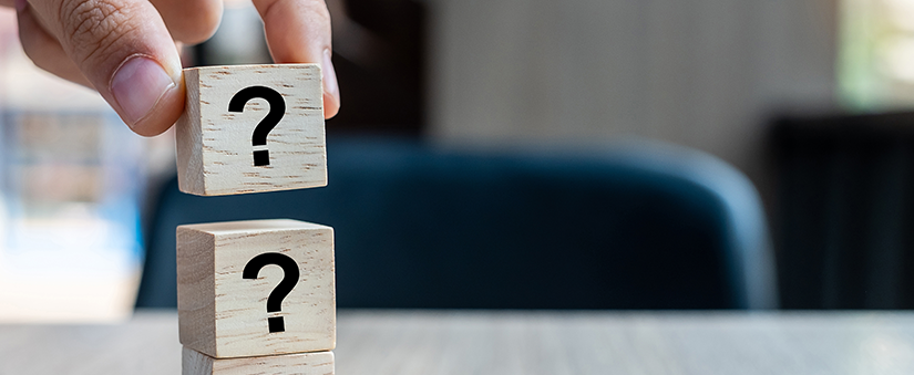 Comissão: uma mão empina bloquinhos com sinais de interrogação