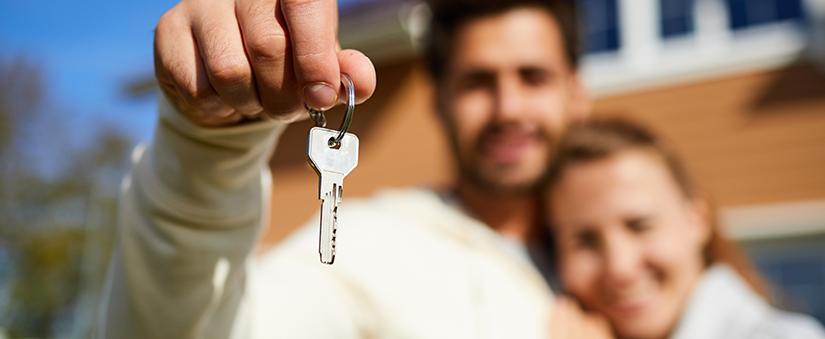 Consórcio ou financiamento - Casal segurando chave de imóvel
