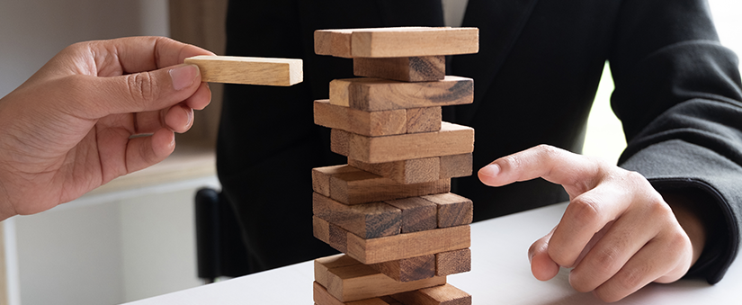 Indicação de clientes: um gestor empilha blocos de madeira como se fosse um prédio