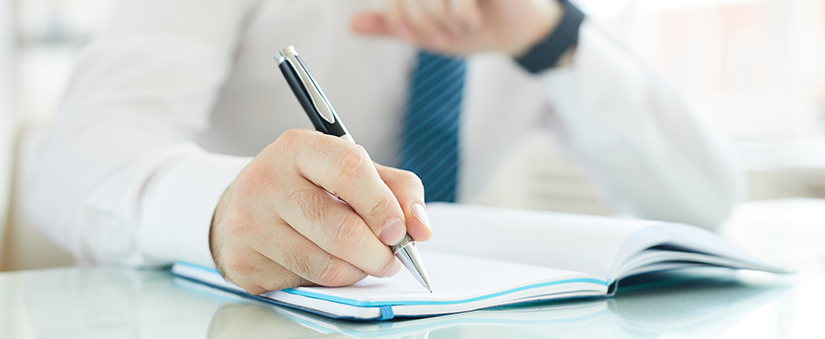 Pós-venda para corretores: corretor escreve em caderno enquanto checa o relógio de pulso