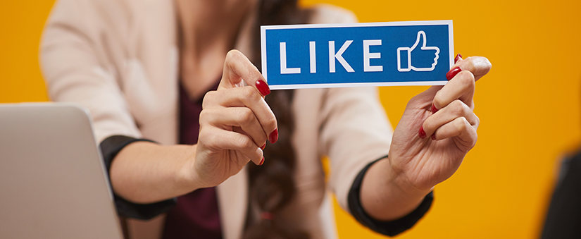 Taxa de resposta: mãos femininas seguram uma plaquinha de "like"