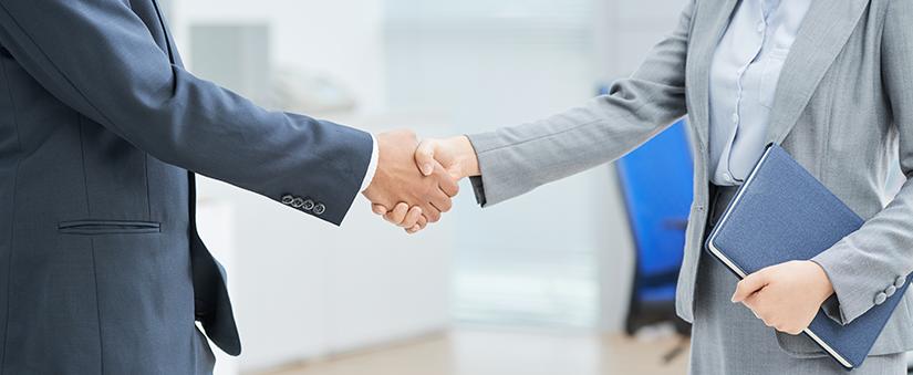 Canal de atendimento - Homem e mulher de terno dando aperto de mãos