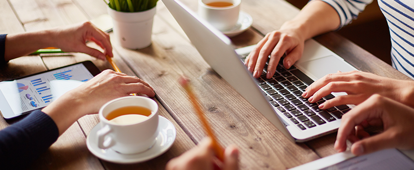 Site para incorporadoras: uma pessoa utiliza o notebook enquanto outra aproveita uma bebida quente