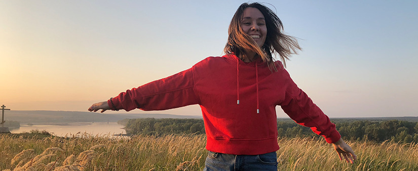 Marketing de Experiência: mulher sorridente abre os braços numa campina