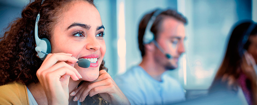 Suporte ao cliente: atendente fala sorridente ao telefone através do headset de atendente