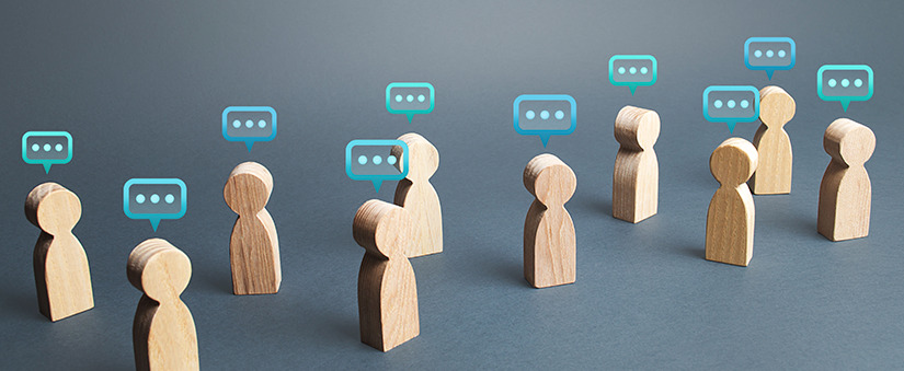 Bonequinhos de madeira com balões de conversa acima das cabeças