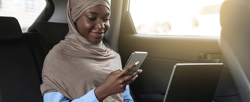 Design thinking: colaboradora usa celular enquanto anda como passageira de um carro