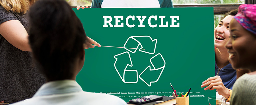 Pessoas observam placa de reciclar