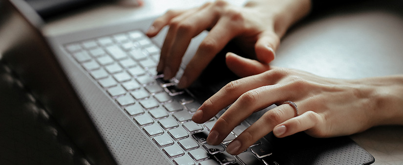 Pessoa digita teclas de um laptop