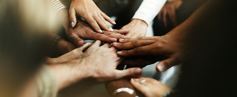 close de diversas pessoas dando as mãos