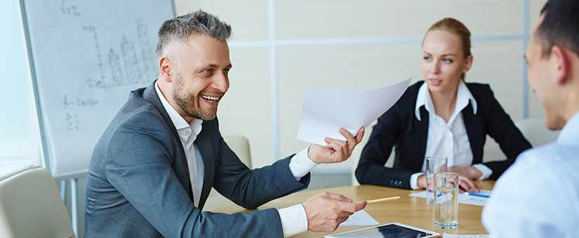 Grupo de funcionários sorriem numa reunião em torno duma mesa. Grupo de funcionários sorriem numa reunião em torno duma mesa.