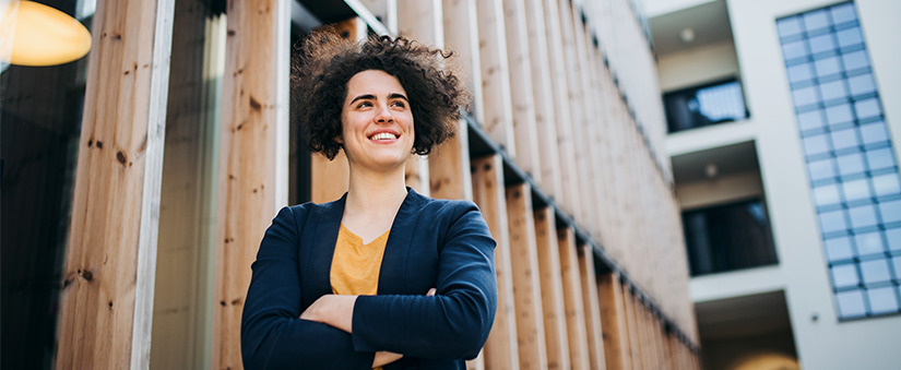 Especulação imobiliária: empresária olha para o além de braços cruzados em frente a uma obra. Especulação imobiliária: empresária olha para o além de braços cruzados em frente a uma obra.