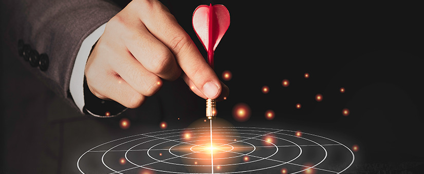 segmentos do mercado imobiliário Marketing de Segmento: close numa mão fixando um dardo num alvo.