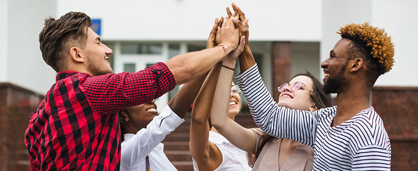 Marketing de Segmento Marketing de Segmento: grupo de jovens juntando as mãos em sinal de vitória.