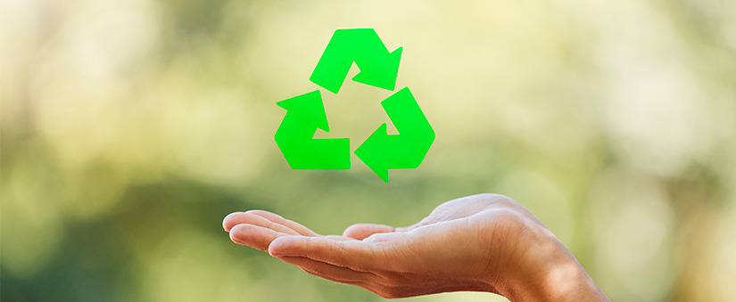 Métodos e práticas sustentáveis na construção civil práticas sustentáveis: close de uma mão e, acima, o símbolo de reciclagem.