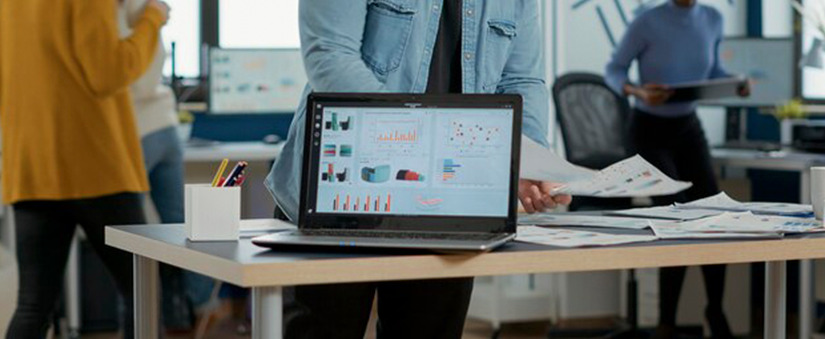 integração CV e UAU destaque para um notebook numa mesa de escritório, com algumas pessoas trabalhando ao fundo, com um dashboard na tela.