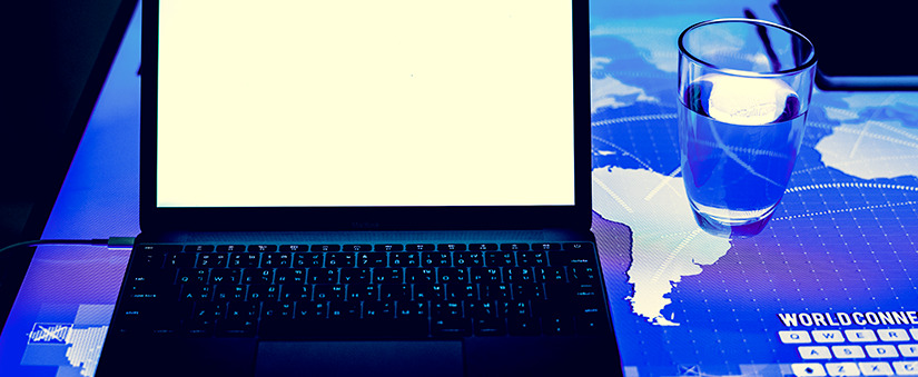 cultura digital na incorporadora cultura digital: imagem de um notebook ao lado de um copo com água