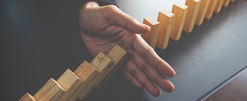 Técnicas de gestão Técnicas de gestão: blocos de madeira enfileirados e uma mão na metade da fila, bloqueando alguns blocos que caem.