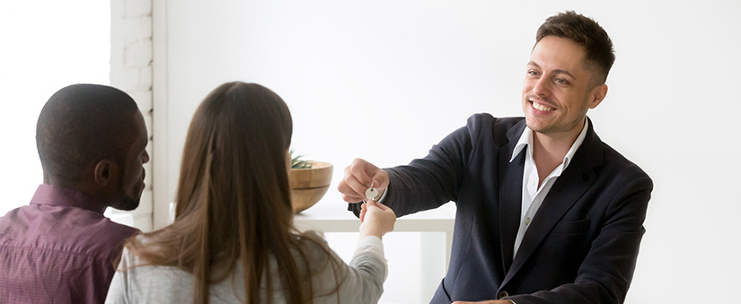 Taxas e impostos Taxas e impostos: imagem de homem entregando uma chave a um homem e uma mulher.