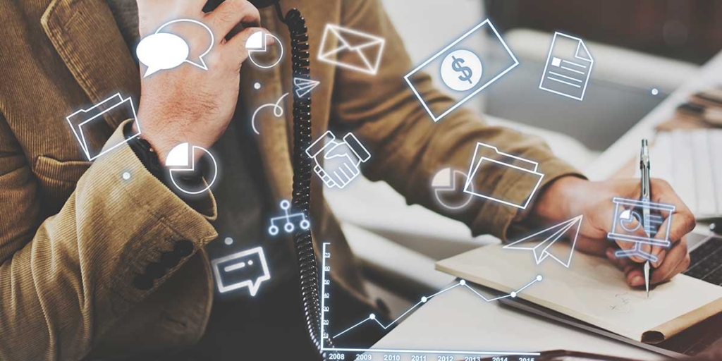 tecnologia persuasiva tecnologia persuasiva: cole nas mãos de uma pessoa escrevendo num papel numa mesa cheia de papeis. À frente alguns ícones de balões de fala, aperto de mão, gráficos e cédula de dinheiro.