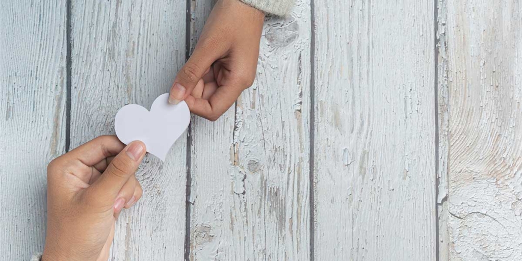 Captar novos clientes Captar novos clientes: imagem de duas mãos segurando um coração de papel.