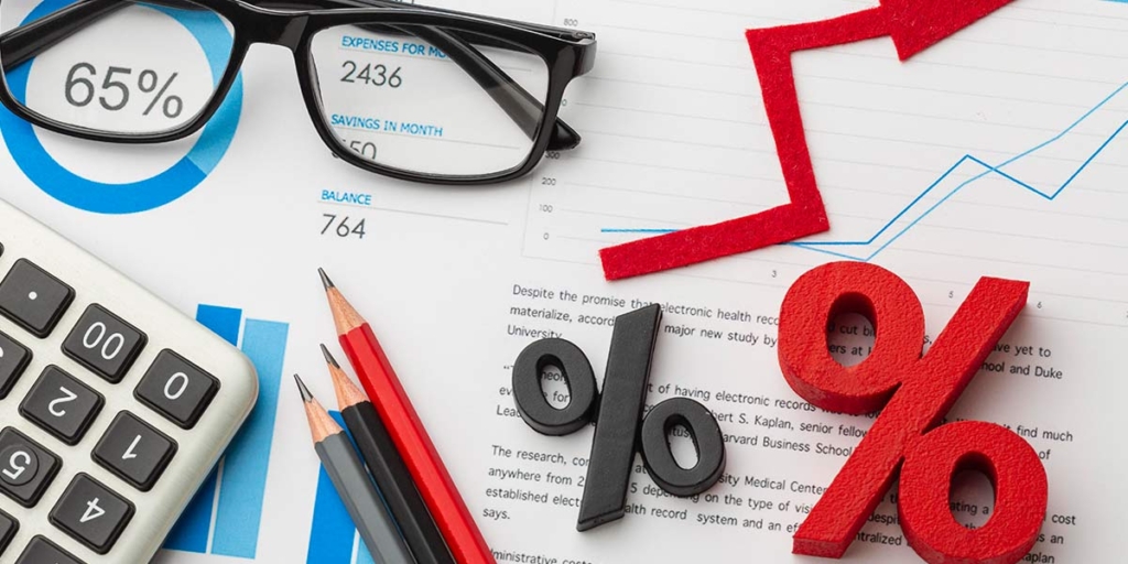 FGTS para compra de imóvel Imagem de vários papeis vistos de cima com gráficos. Em cima dos papeis alguns lápis, um óculos, uma calculadora.