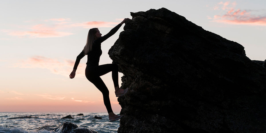 captar leads captar leads: silhueta de uma mulher escalando uma montanha.