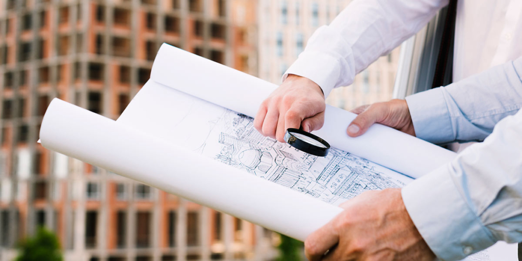 vistoria de apartamento novo vistoria de apartamento novo: close nas mãos de duas pessoas segurando um mapa e uma lupa.