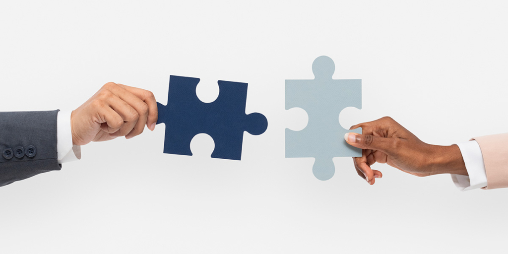 Software-para-construção-civil Software-para-construção-civil: duas mãos segurando peças de quebra-cabeça, uma de frente para a outra.