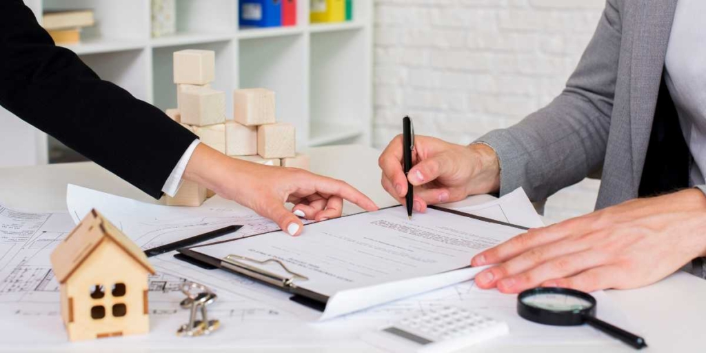 Registro de Incorporação Imobiliária: close nas mãos de duas pessoas assinando um papel.