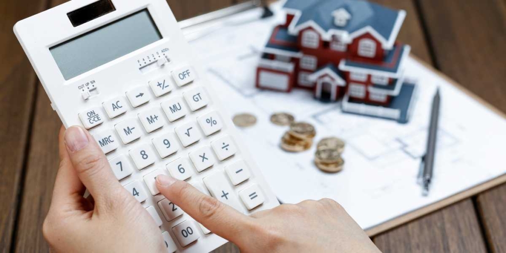 Repasse de financiamento imobiliário Repasse de financiamento imobiliário: close em mãos usando uma calculadora.