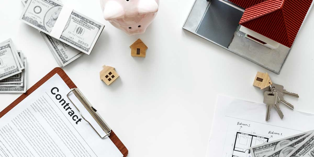 Área de Corretagem Área de Corretagem: mesa vista de cima com alguns papeis, chaves, miniatura de cada e cédulas.