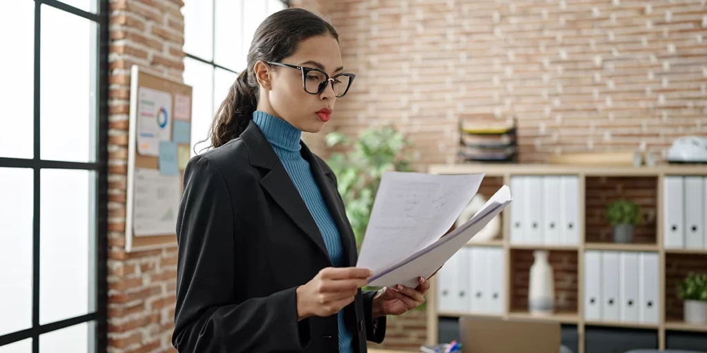 Documento de venda de imóvel Documento de venda de imóvel: imagem de uma mulher segurando alguns papeis num escritório.