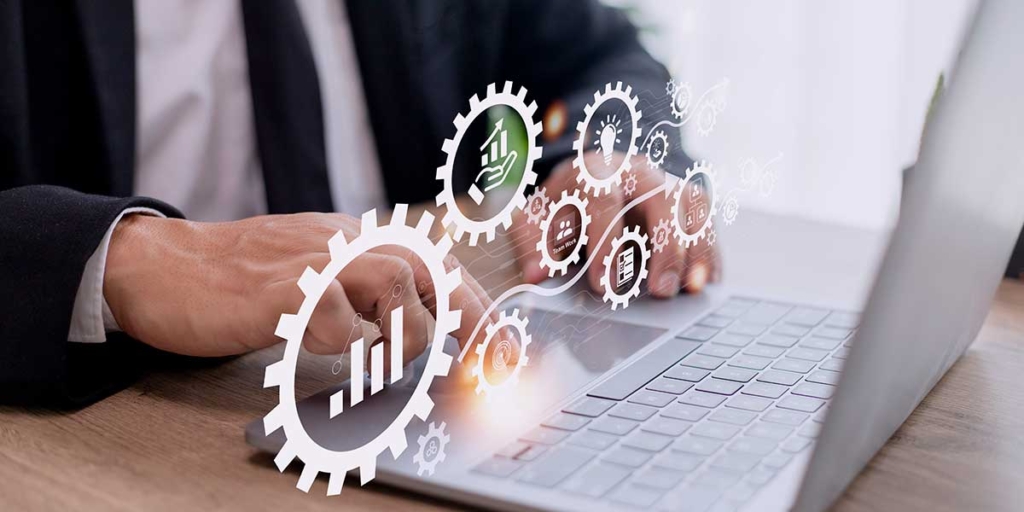 Escalabilidade de software Escalabilidade de software: close nas mãos de uma pessoa digitando num notebook. Acima de suas mãos alguns ícones de gráficos.