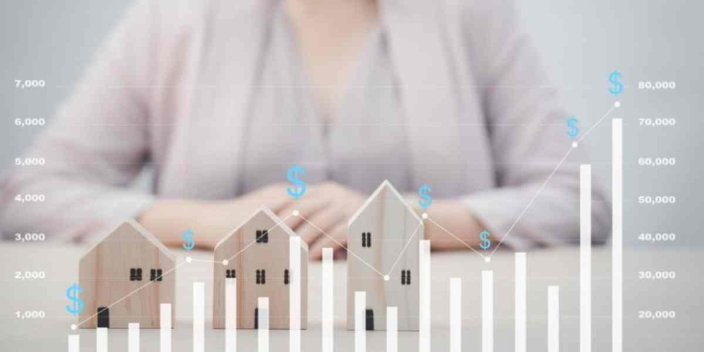 Indicadores imobiliários Indicadores imobiliários: imagem de um gráfico de barras crescente e algumas casas em miniatura ao fundo acompanhando o tamanho do gráfico. Mais ao fundo, uma pessoa sentada à mesa.