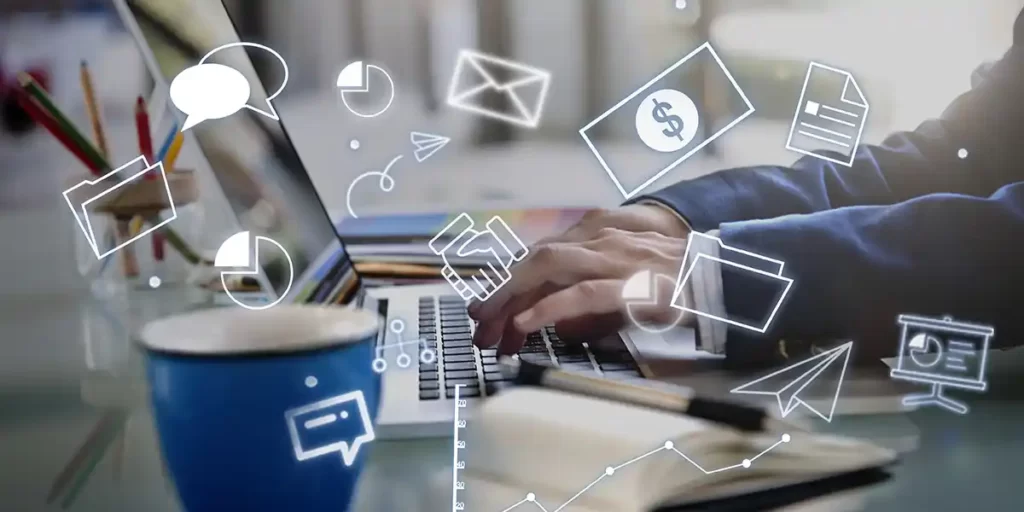 Captação de clientes no mercado imobiliário Captação de clientes no mercado imobiliário: close em mãos digitando num notebook. Em destaque na imagem algumas ilustrações de balões, cédulas de dinheiro, pastas, papeis, etc.