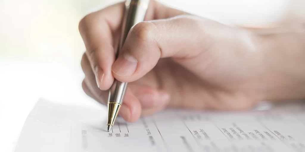 Carteira de corretor de imóveis Carteira de corretor de imóveis: imagem de uma mão escrevendo num papel.