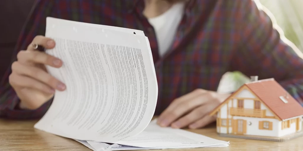 NIRF NIRF: close nas mãos de uma pessoa numa mesa, folheando papeis.