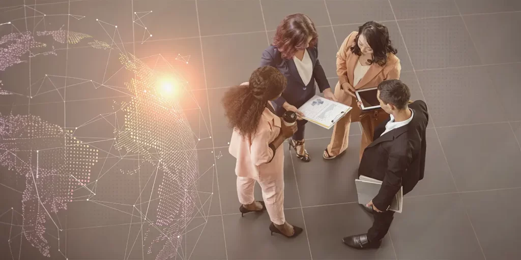 Software de Gerenciamento Software de Gerenciamento: imagem vista de cima de de quatro pessoas conversando, segurando papeis, tablets, etc.