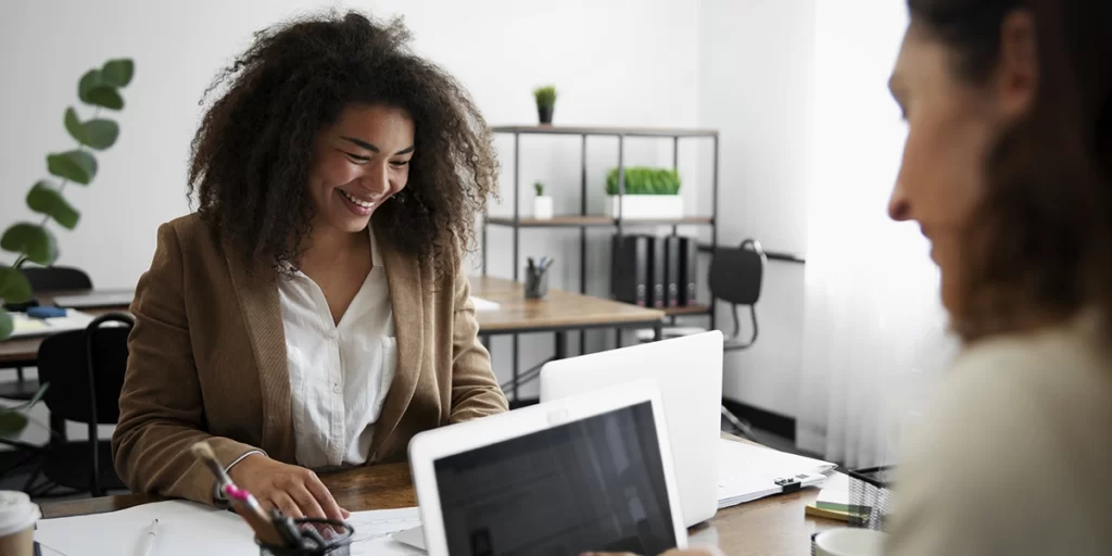 Vendas Consultivas Vendas Consultivas: imagem de duas mulheres num escritório, numa mesa.