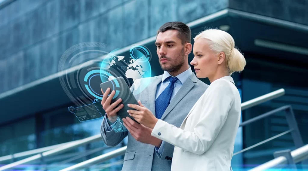 Cursos para corretor de imóveis Cursos para corretor de imóveis: imagem de um homem e uma mulher usando terno, olhando para um tablet.