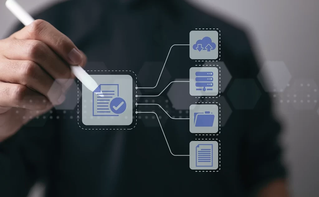 Gestão Orientada Gestão Orientada: close numa mão marcando com um lápis a tela com alguns ícones de pastas, papeis e compartilhamento de arquivos.