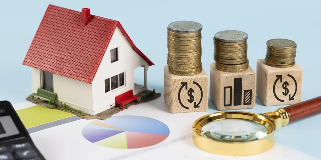 Índice Imobiliário Índice Imobiliário: A imagem mostra uma representação financeira. Há uma casa de brinquedo com uma telhas vermelhas, um banco de moedas de diferentes tipos e valores, um calendário de mês, um contador de dinheiro, um estoque de moedas e um olho de peneira. Tudo isso está sobre um papel com um gráfico de rosa de ponto e um contador de dinheiro.