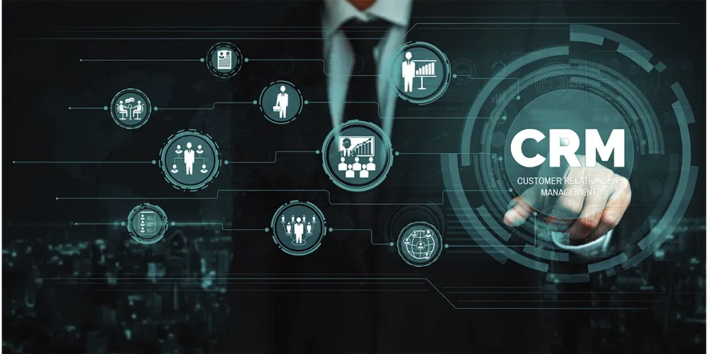 CRM para incorporadoras CRM para incorporadoras: close na mão de uma pessoa apontando para a tela. Em destaque na tela alguns ícones que representam relacionamento. O homem aponta para o maior dos ícones, onde vemos a sigla CRM.