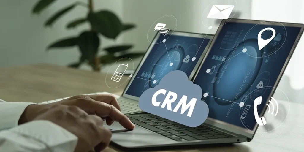 CRM para incorporadoras CRM para incorporadoras: close nas mãos de uma pessoa digitando num teclado de notebook. Da tela sai um ícone com a sigla CRM.