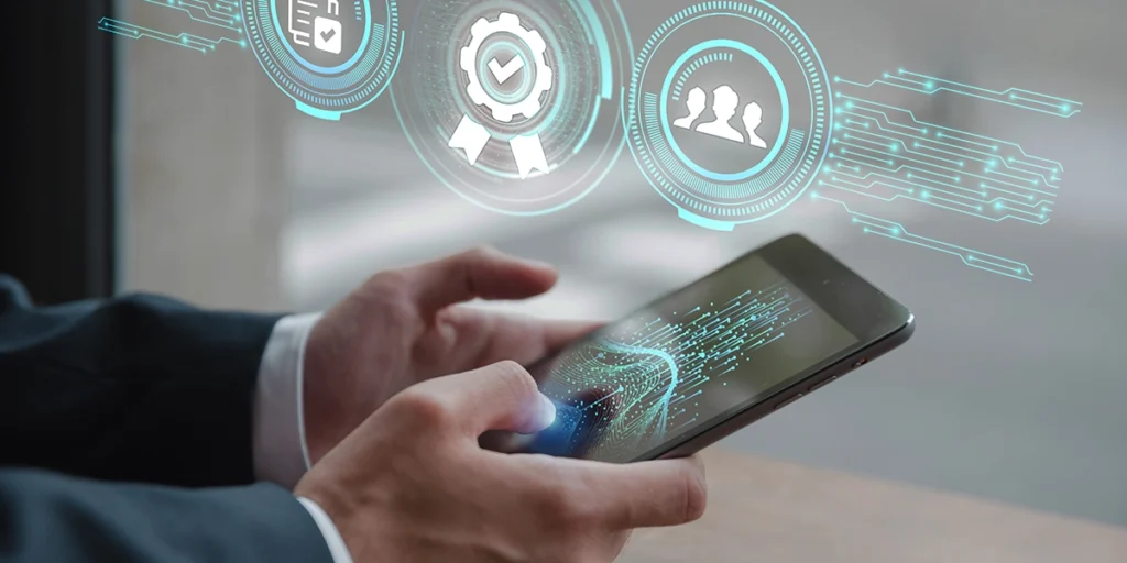 imóveis de incorporadoras imóveis de incorporadoras: A imagem mostra uma pessoa vestida com traje segurando um celular inteligente com diferentes icônicos na tela, como um icônico de redes sociais, um icônico de busca e um icônico de mapas. A pessoa olha para a tela com uma expressão curiosa. O fundo é uma janela de vidro com uma vista da parede de uma cidade. A imagem está em preto e branco.