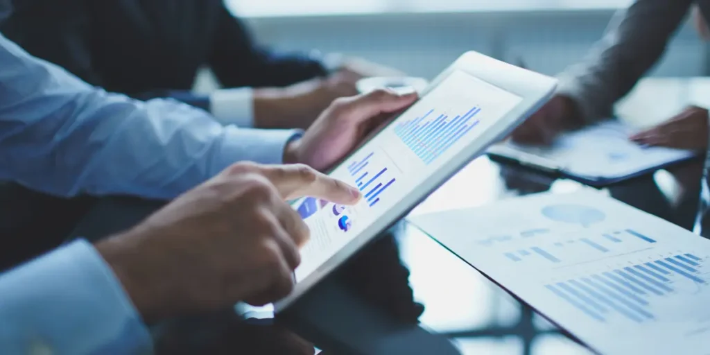 gestão comercial no mercado imobiliário gestão comercial no mercado imobiliário: close de mãos segurando segurando um tablet com gráficos.